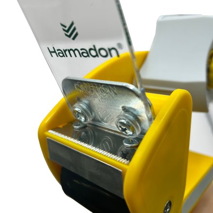 Zbliżenie ostrza dyspensera do taśmy Harmadon RT-82276 z bezpieczną osłoną i metalowym mechanizmem cięcia do precyzyjnego zaklejania kartonów w magazynie i e commerce